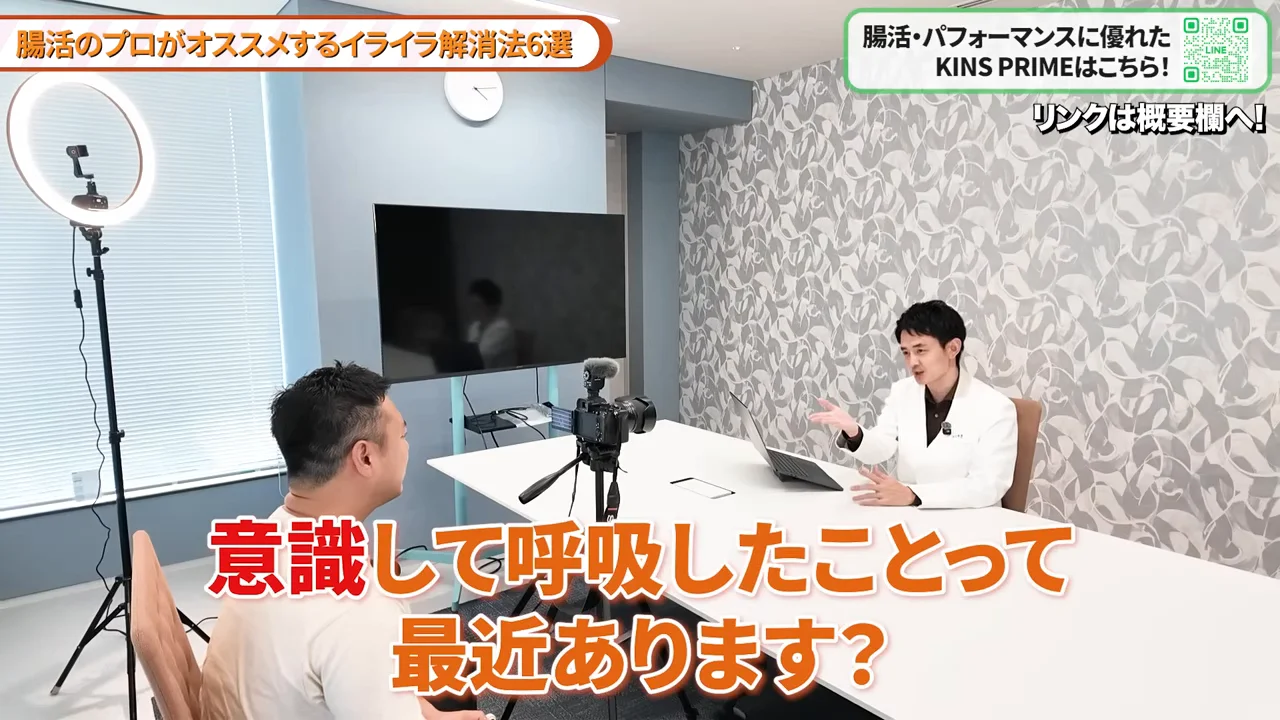 スタジオのテーブルを挟んで白衣の男性が話している様子