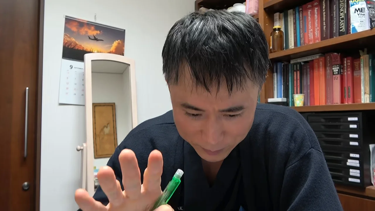 男性がペンを持ちながら手を開いて下を向いている様子