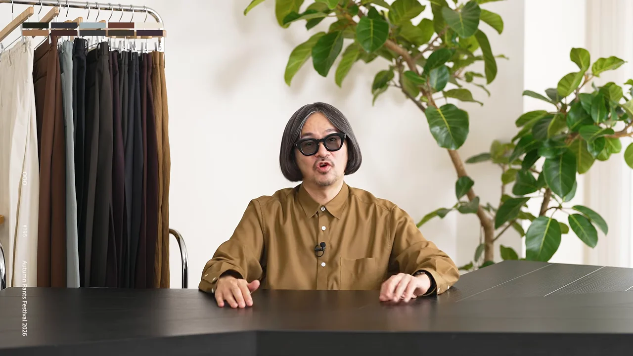 男性が机に両手を置いてカメラに向かって話している。