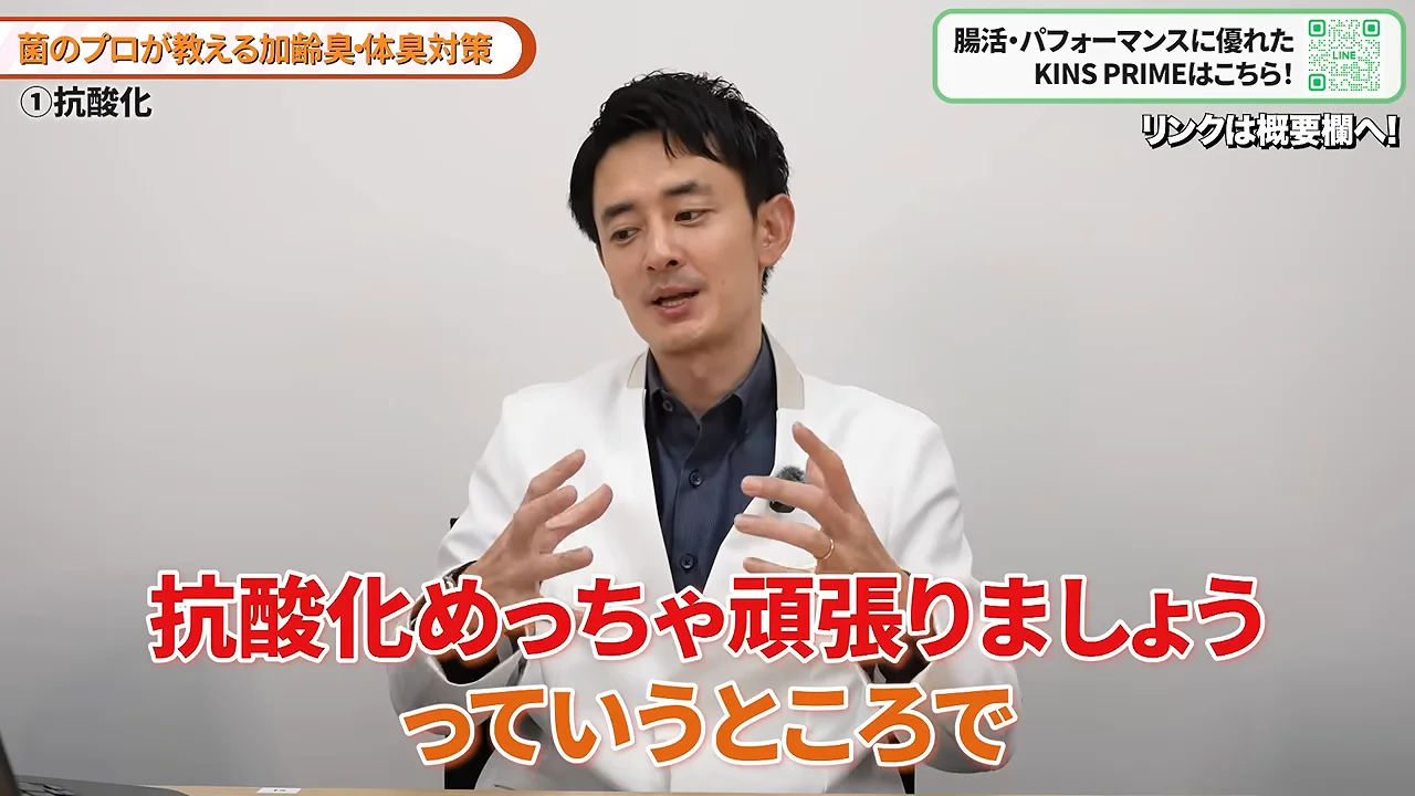 白衣を着た男性が両手を広げてジェスチャーを交えながら説明している様子。
