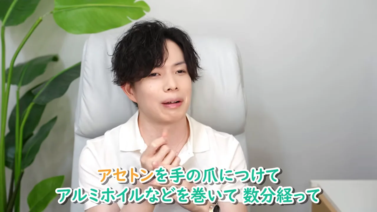白いシャツを着た男性が椅子に座り、手を組んで話しています。