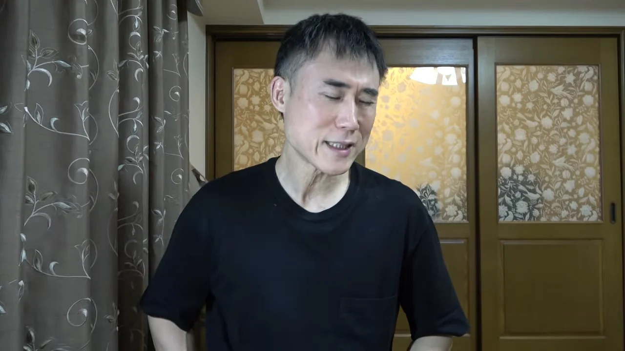 男性が正面を向いて表情を動かしながら話している様子。