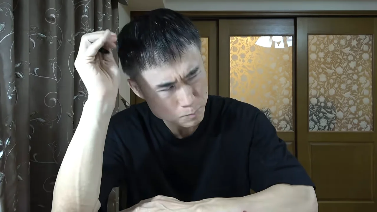 頭に手を当てて考え込むような表情の男性