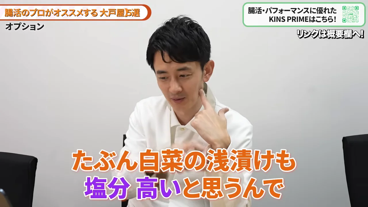 男性が手で首元に触れながら話している様子