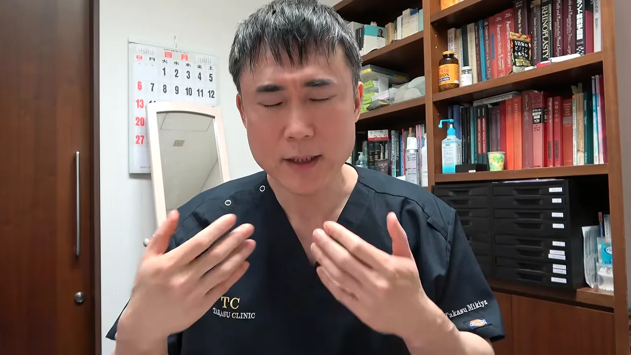 目を閉じて両手を前に出しながら話す男性