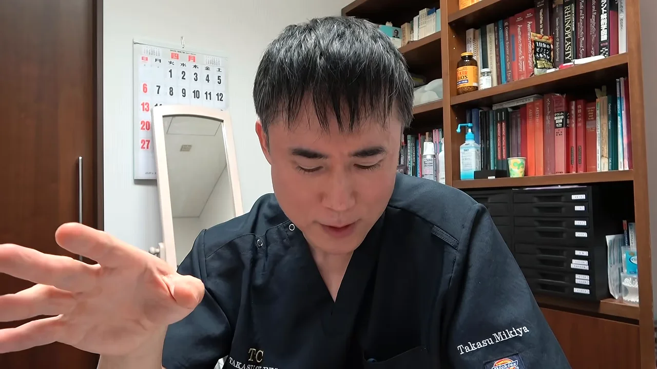 視線を落とし右手を手前にかざしながら話す男性