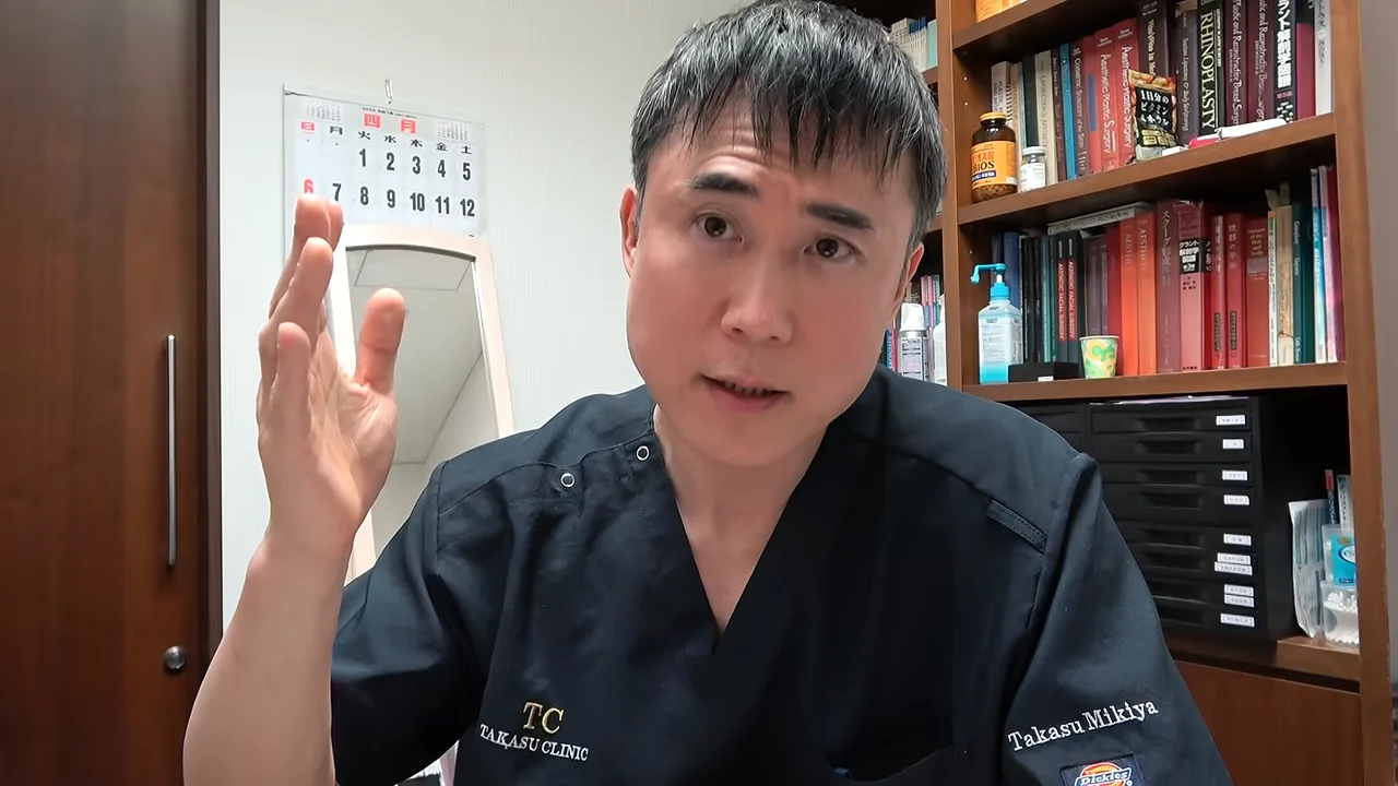 右手を顔の横に挙げて身振り手振りを交えながら語る男性