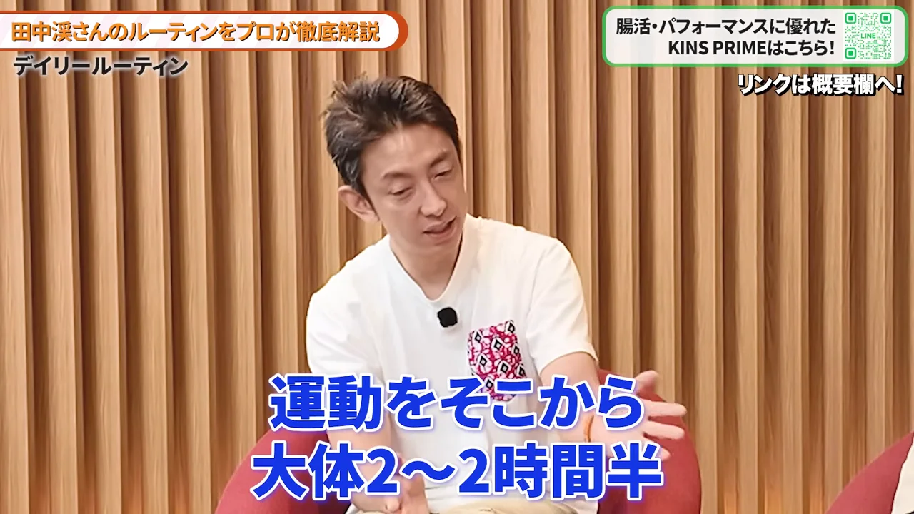 白いTシャツを着た男性が身振り手振りを交えながら話しています。