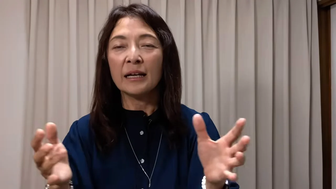 女性が両手を広げてジェスチャーを交えながら話しています。