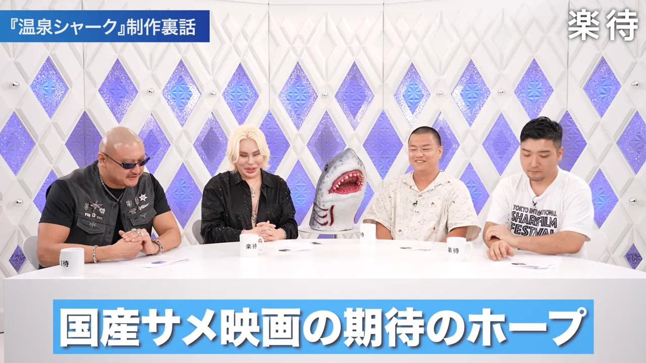 スタジオで4人の男性がテーブルに着席し、画面下に青いテロップが表示されている。