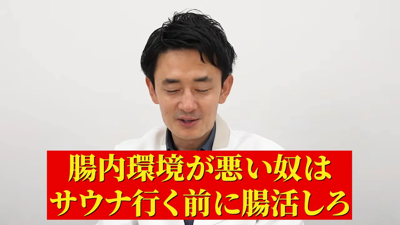 白衣を着た男性が目を伏せて話している様子。
