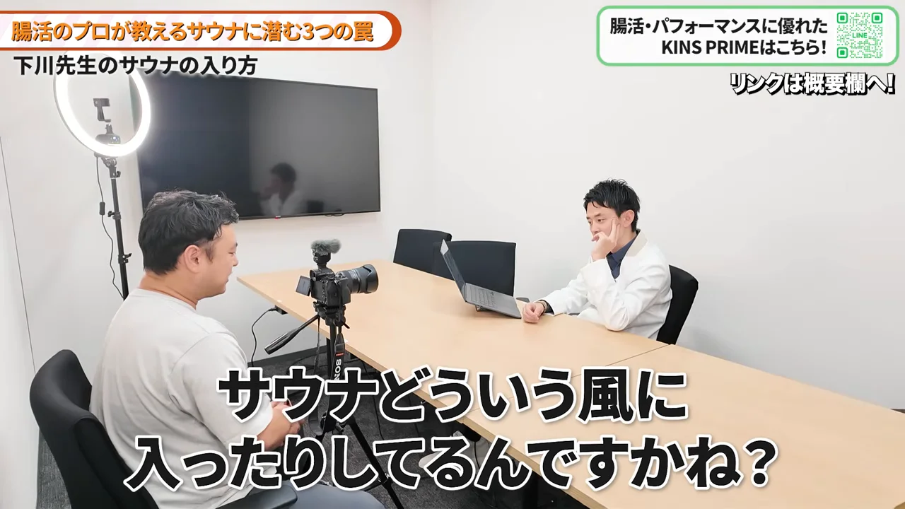 テーブルを挟んで座る2人の男性が対話している様子。
