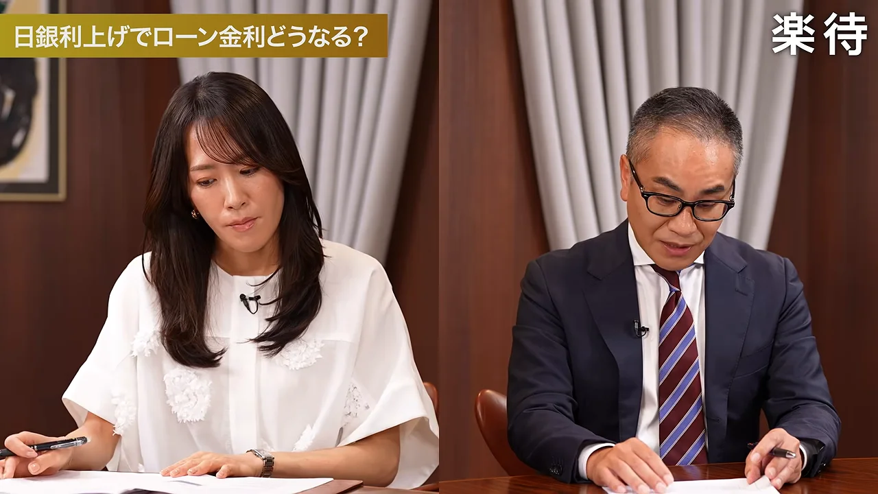 机に向かって手元の書類に視線を落とす白シャツの女性とスーツ姿の男性。