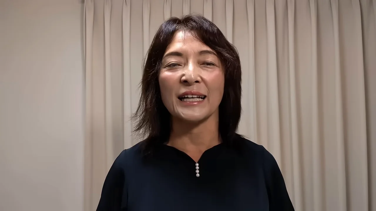 正面を向いて笑顔で語りかけている女性のクローズアップショット。