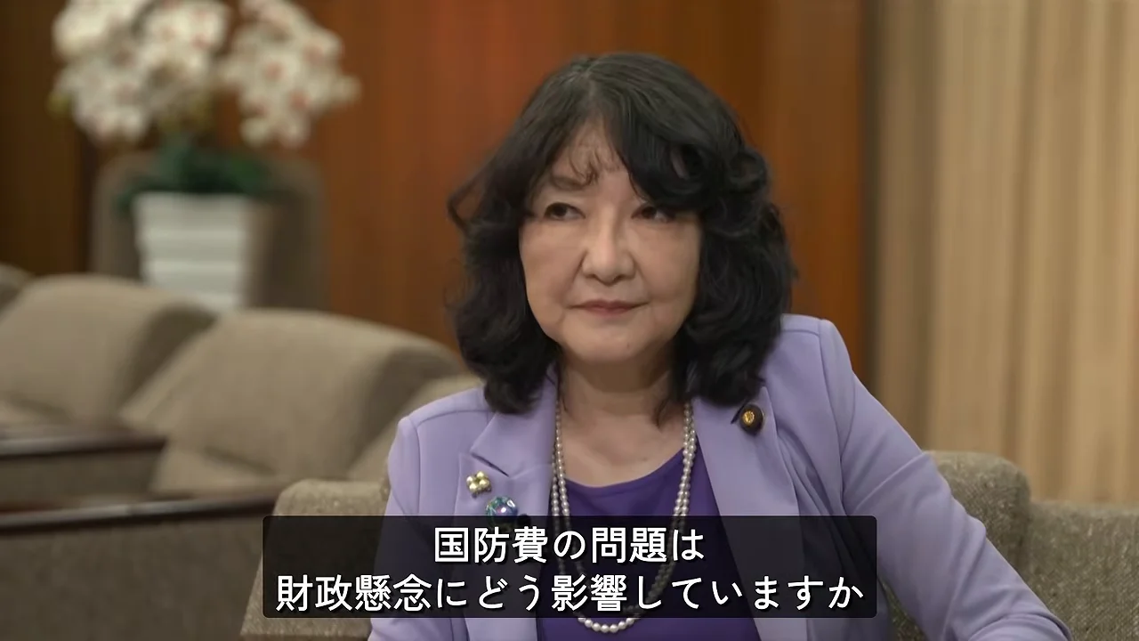 画面下部に質問の字幕が表示され、女性が正面を見つめています。