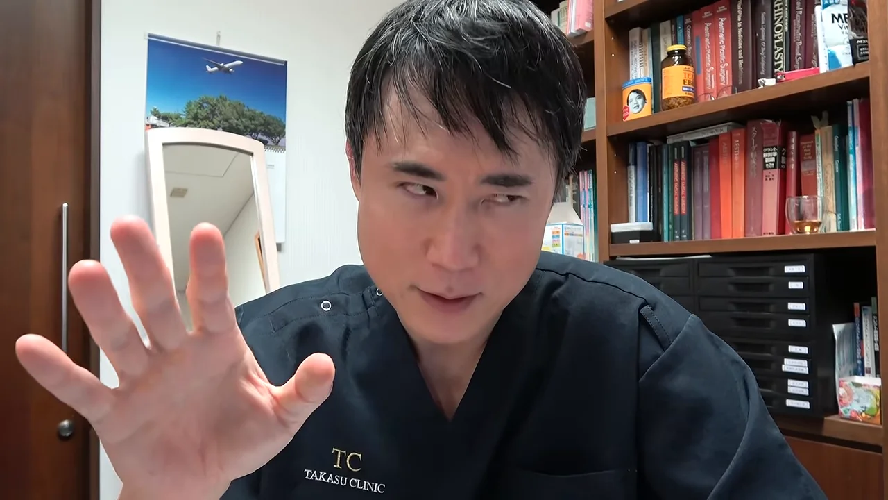 左手をカメラに向けて広げながら話す男性