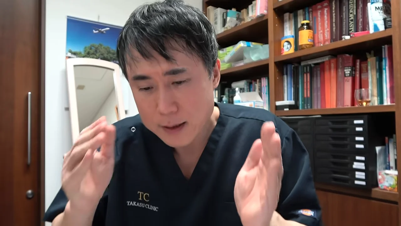 両手を顔の前で立てて身振り交えながら話す男性