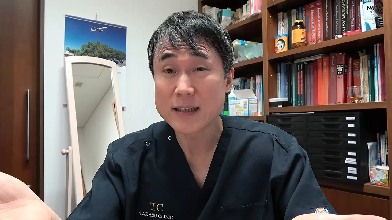 両手を広げて正面を向きながら語る男性