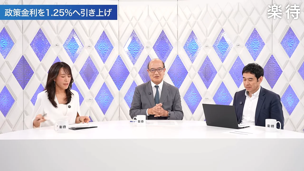 スタジオで中央の男性が話しており、両隣の出演者が耳を傾けている様子。