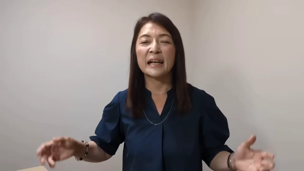両手を広げてジェスチャーを交えながら話す女性