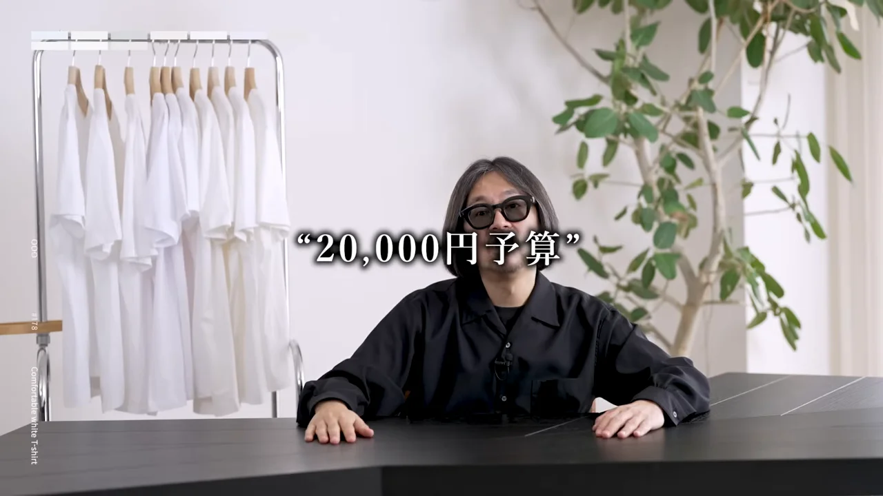「20,000円予算」のテロップとともに、男性がデスクの前で両手を置いて話している様子。