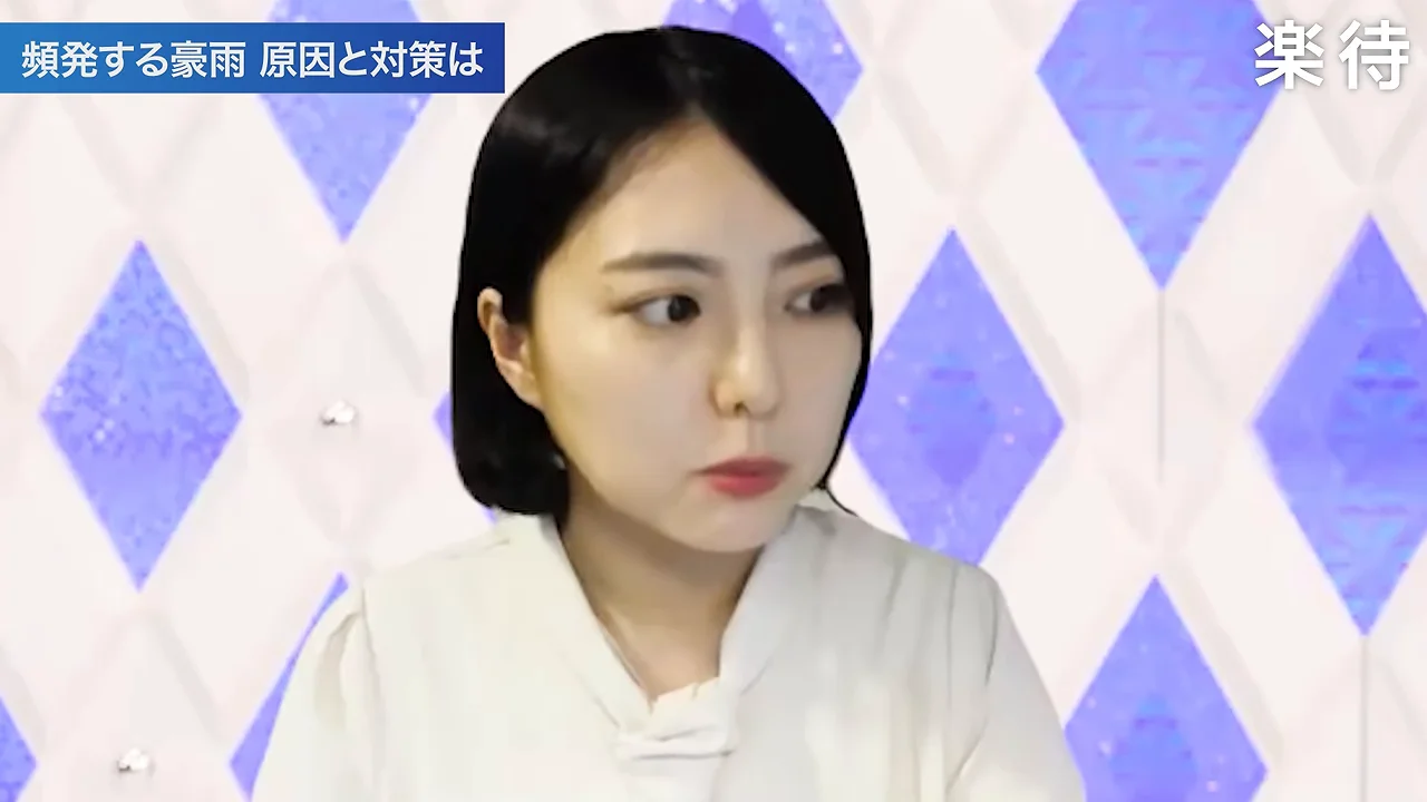 白い服を着た女性キャスターが画面に向かって話している様子