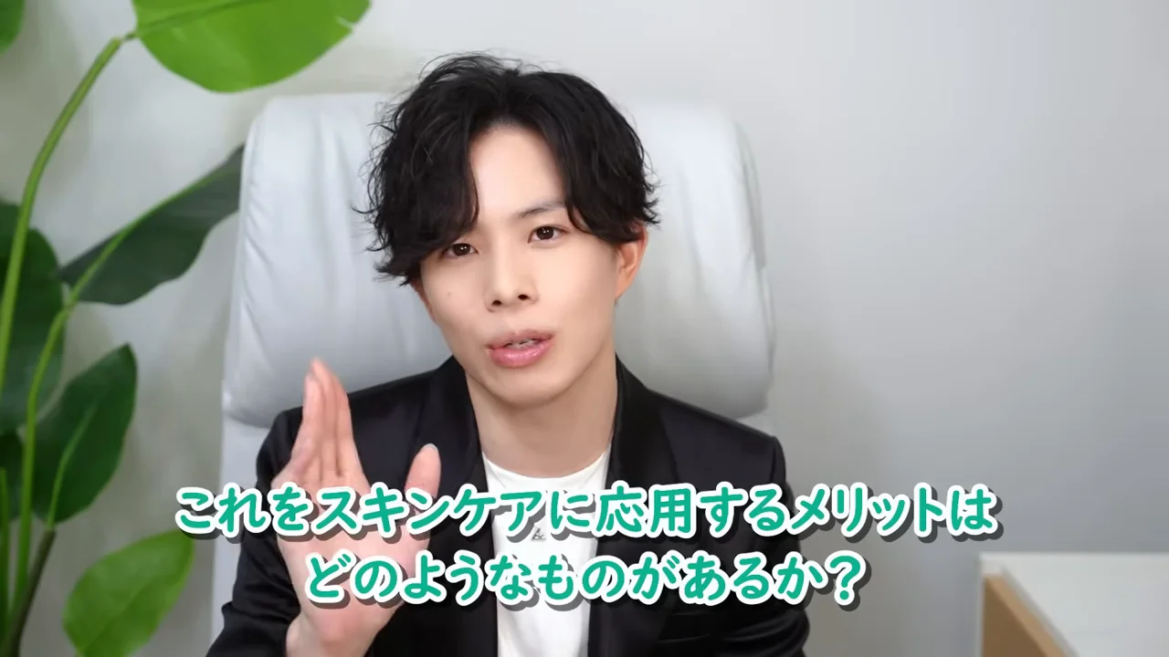 男性がカメラに向かって片手を上げながら話しています。