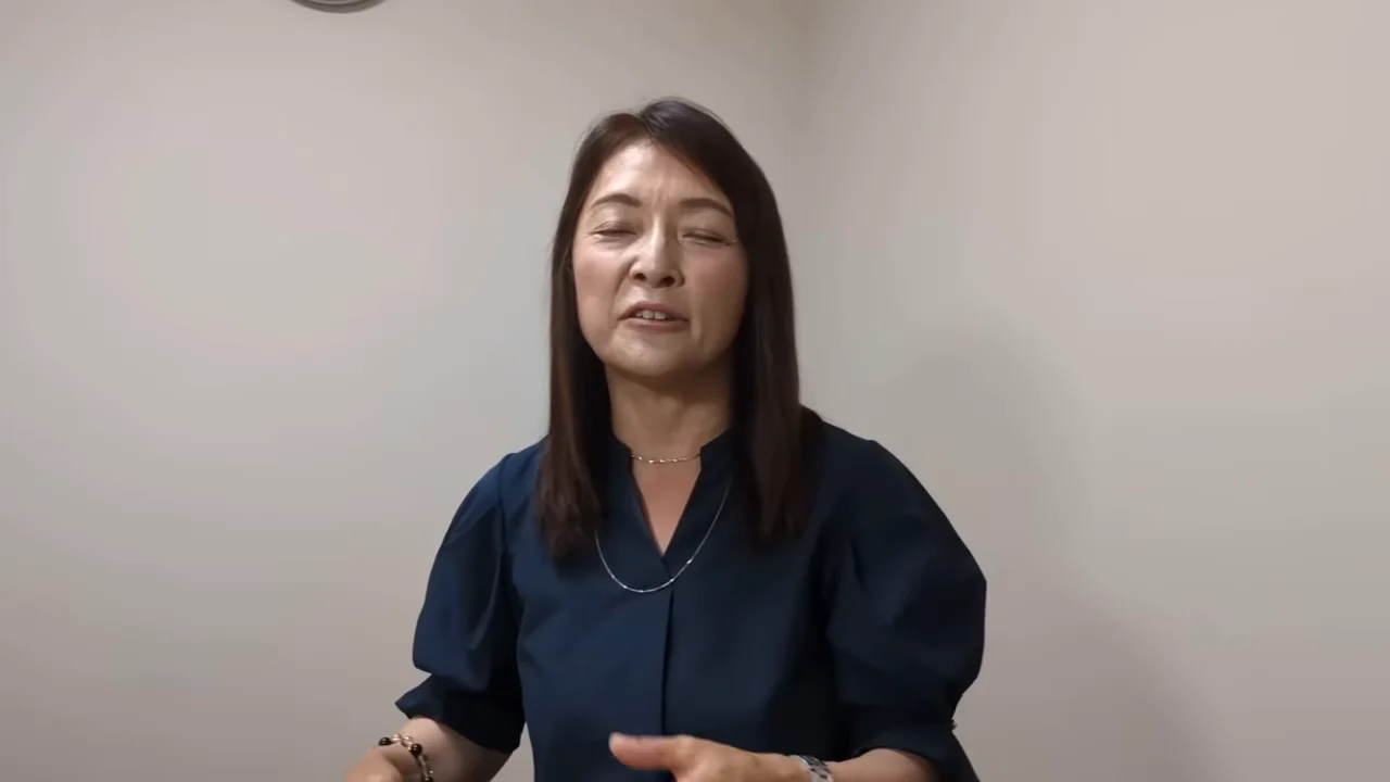 落ち着いた表情で正面を向いて語りかける女性の様子