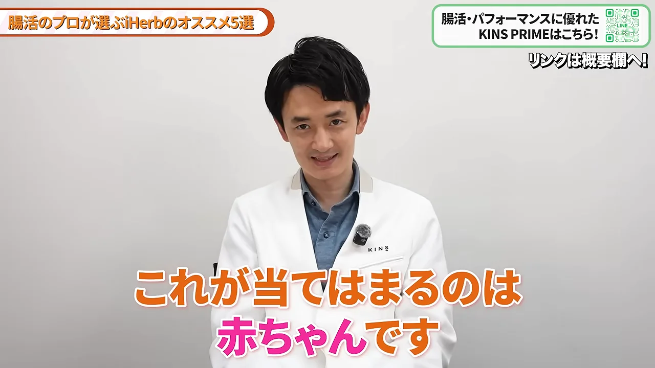 白衣を着た男性が正面を向いてカメラに向かって話しています。