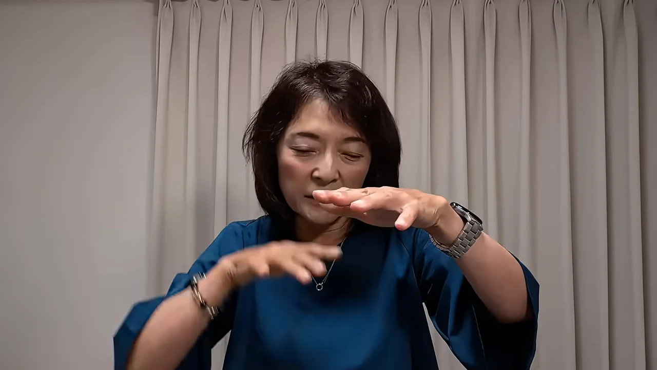 両手を前に出して説明を続ける女性の様子。