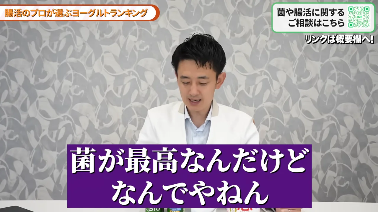 白衣を着た男性が手元を見つめながら話している様子。