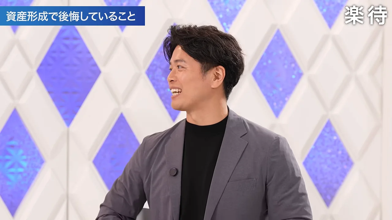 スタジオで笑顔を見せながら横を向いて話す男性