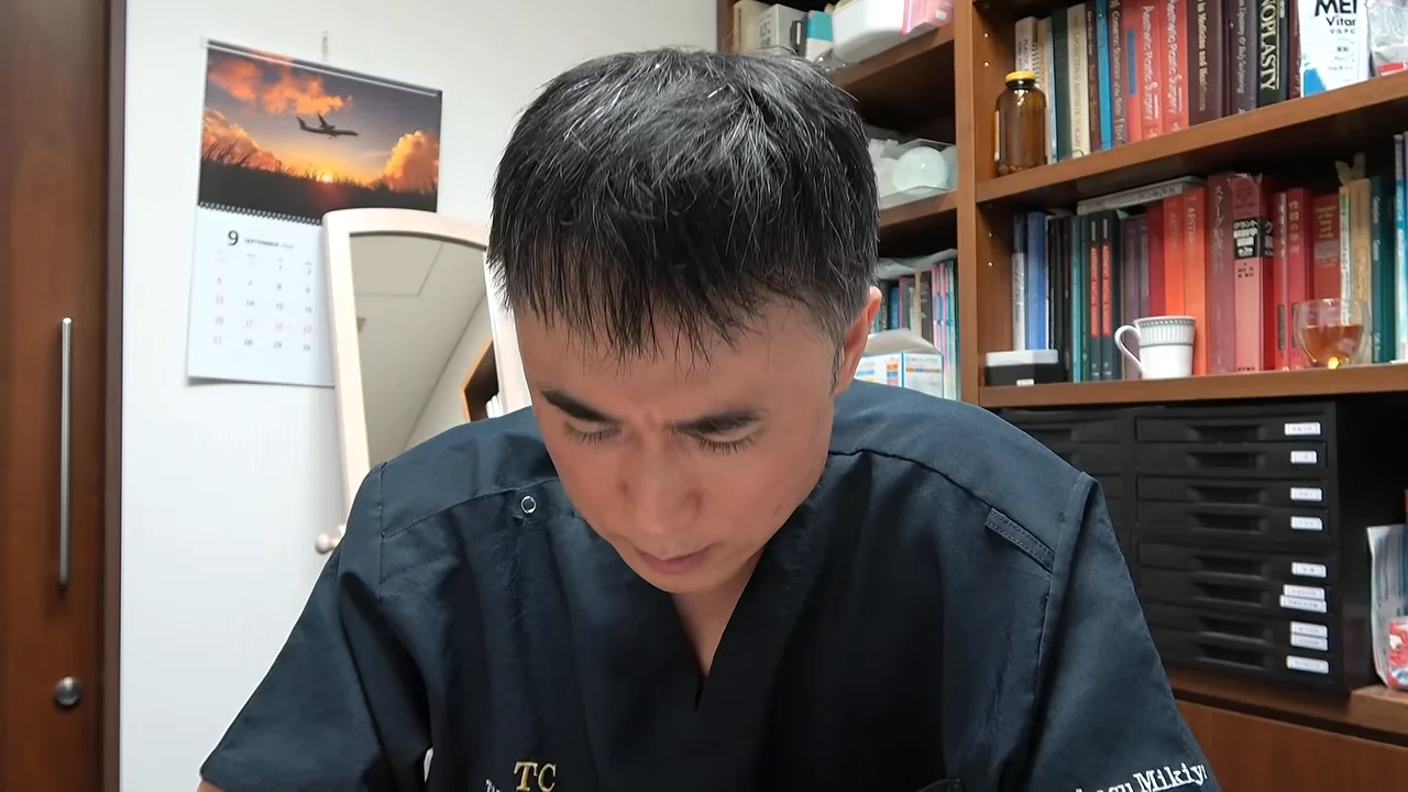 部屋の中で下を向いている男性の姿