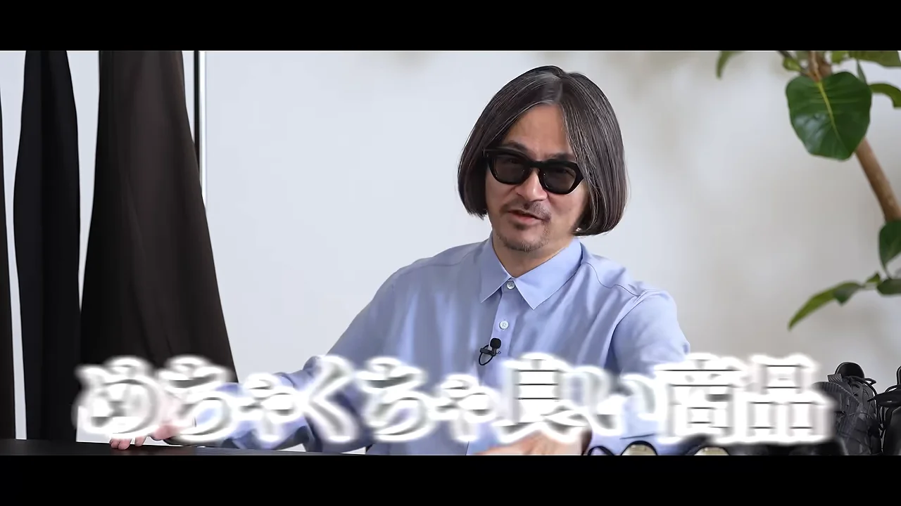 サングラスをかけた男性が室内で話しています。