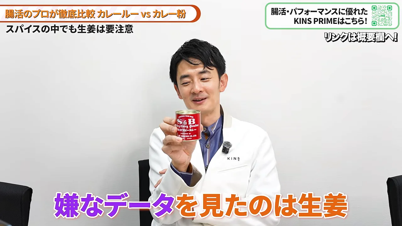 白衣の男性が赤いカレー粉の缶を手に掲げながら解説しています。