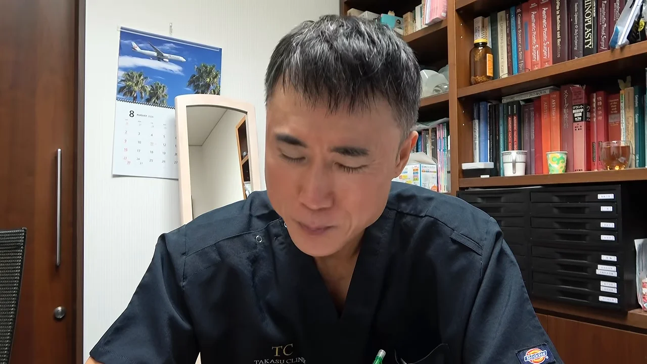 本棚を背にして座る男性が、視線を落としたり前を向いたりしながら話しています。