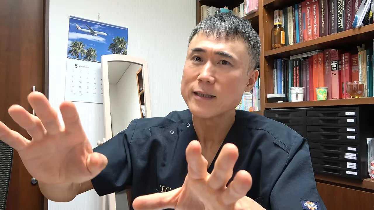 男性が両手をカメラの前に広げ、身振り手振りを交えて熱心に解説しています。