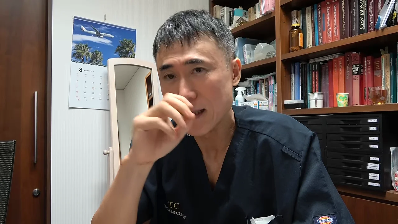 男性が鼻や口元に手をやりながら、カメラに向かって落ち着いた様子で語っています。