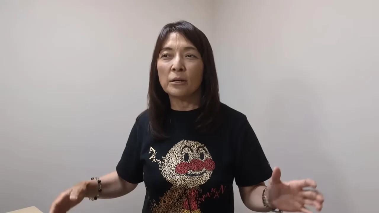 女性が手を動かしながら真剣な表情で語りかけている様子