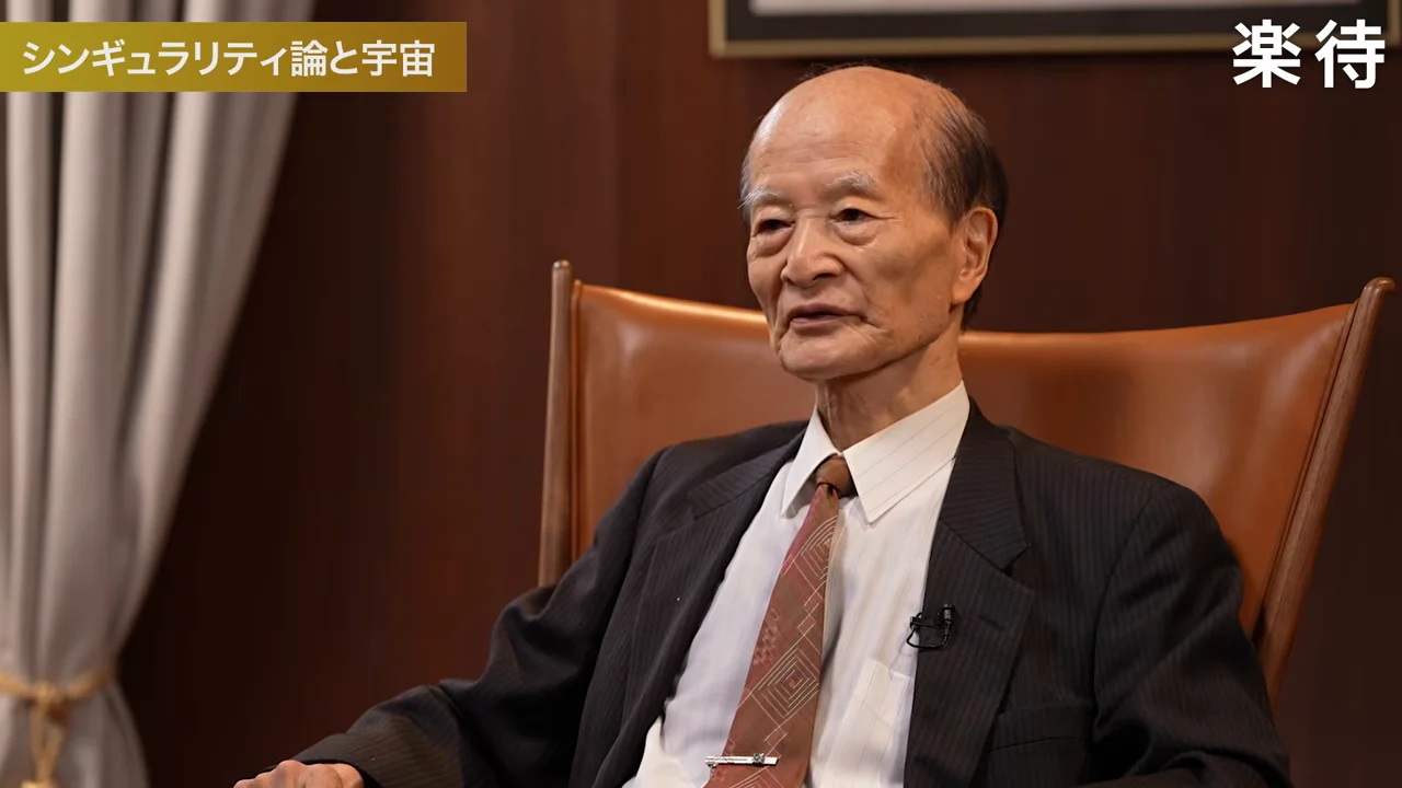椅子に座り真剣な表情を浮かべるスーツ姿の男性