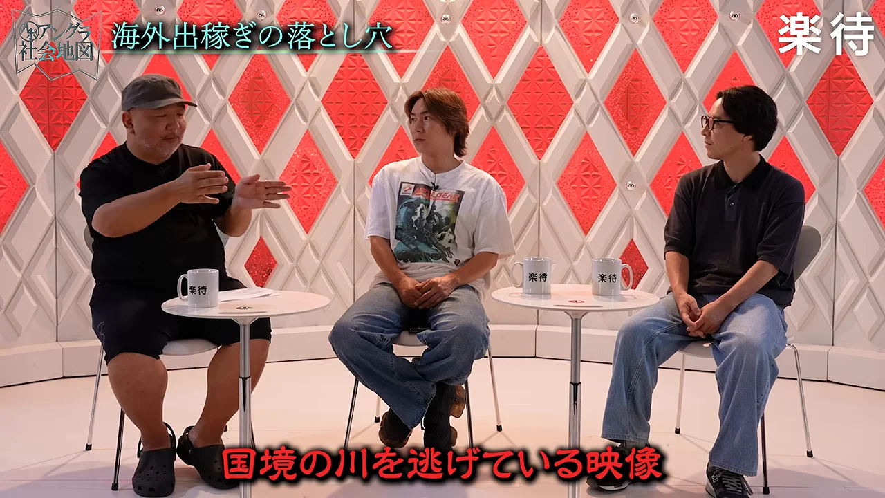 左側に座る男性が身振り手振りを交えながら他の2人に語りかけている様子。