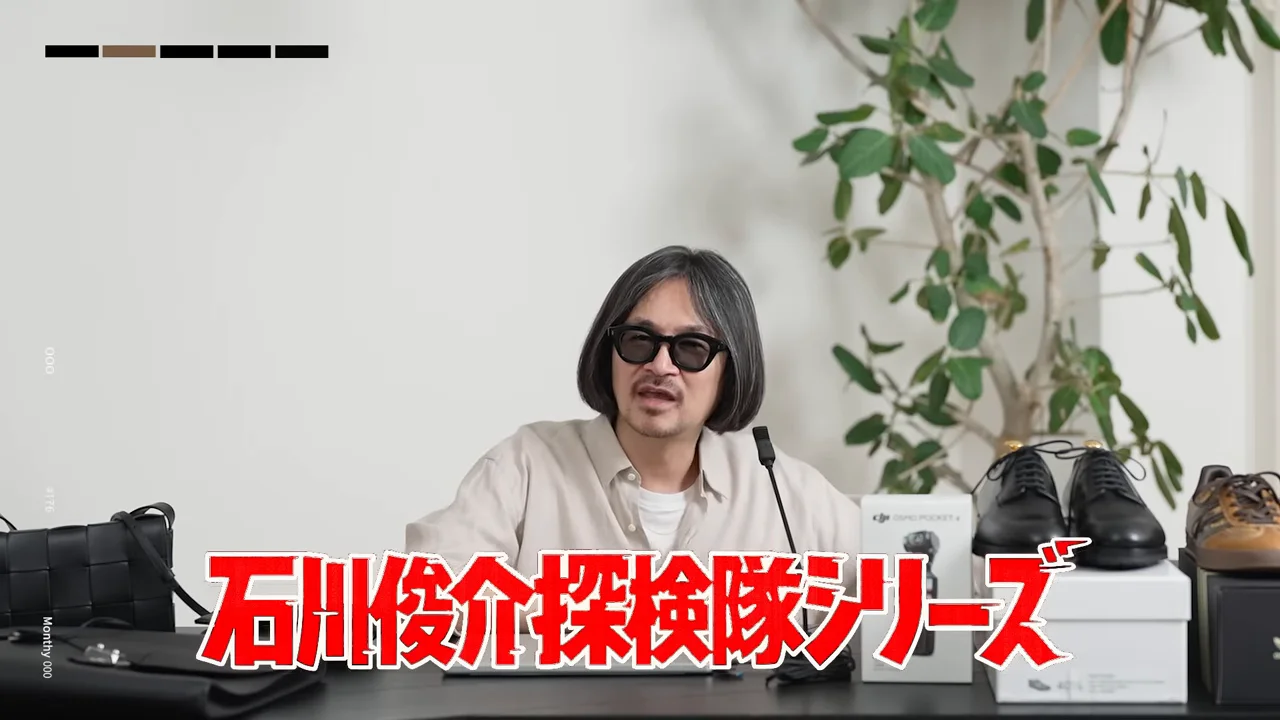 画面中央に大きな赤いテロップが表示され、男性が机の前で語りかけています。
