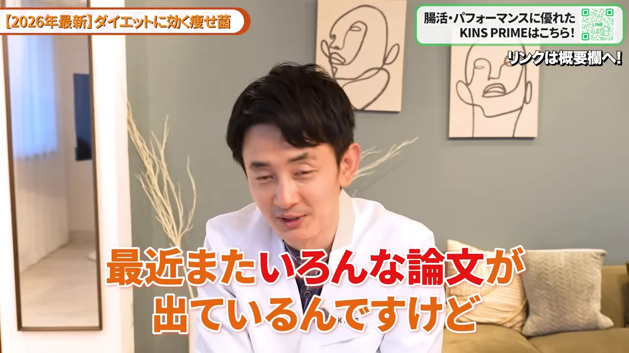 部屋の中で白い服を着た男性が話している様子