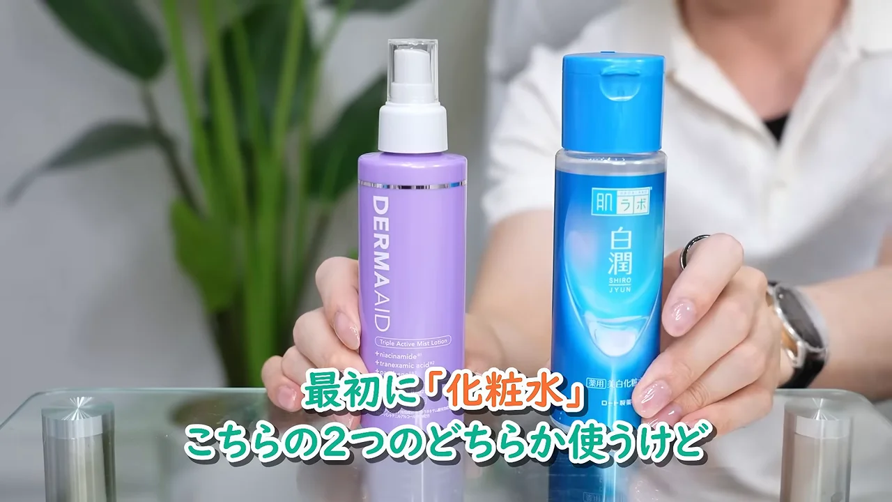 ガラスのテーブルの上に紫色のミスト化粧水と青色の化粧水ボトルが置かれています。