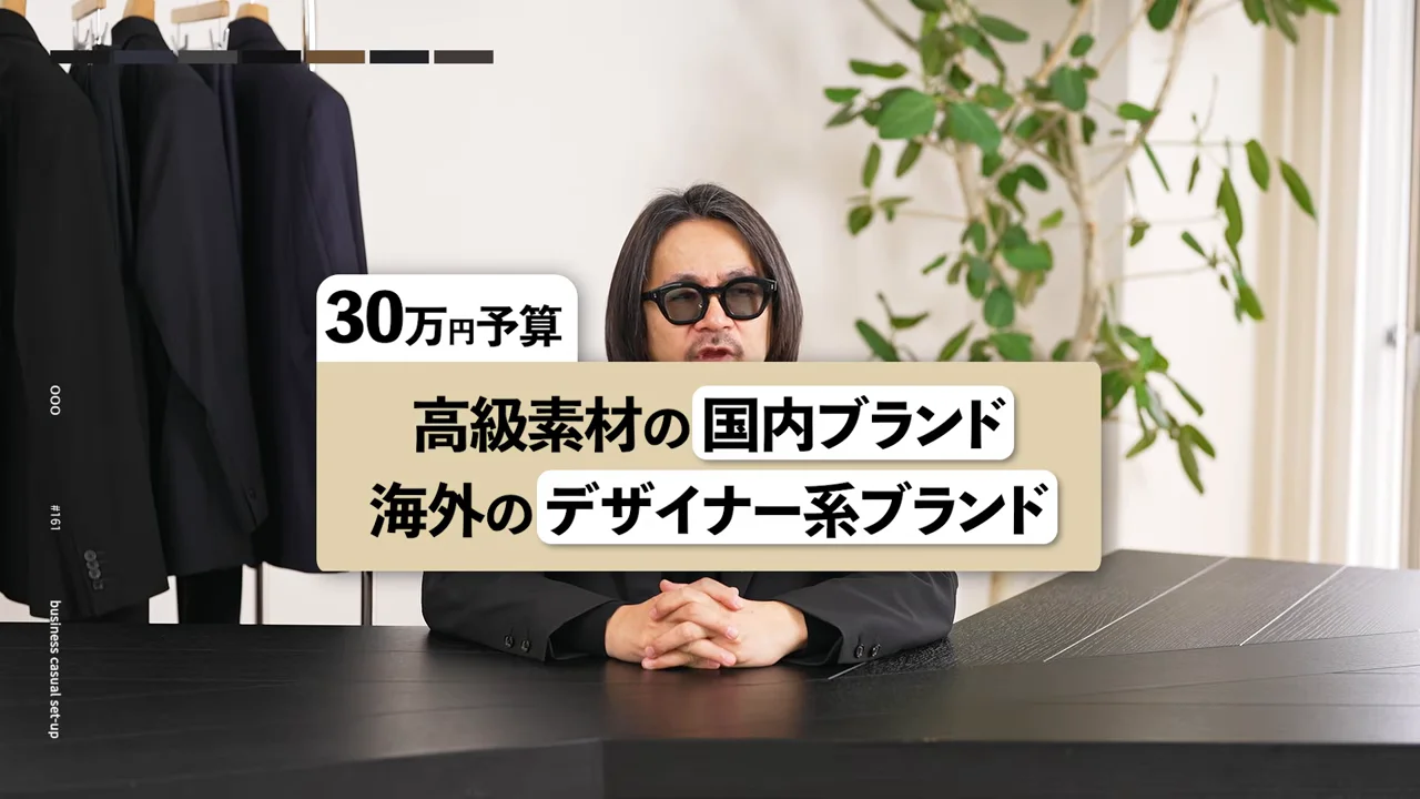 男性がテーブルの前で両手を組み、カメラに向かって話しています。