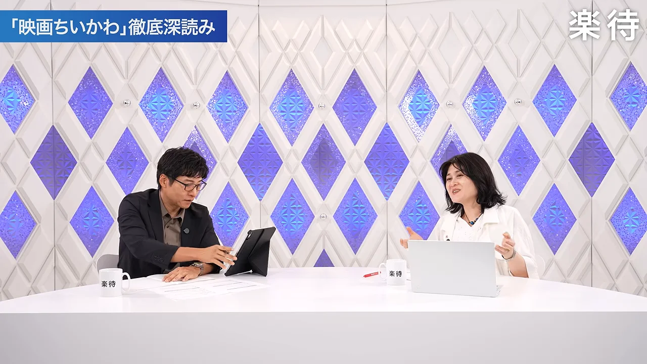 手を開いて説明する女性と、資料を確認しながら聞き入る男性の姿。