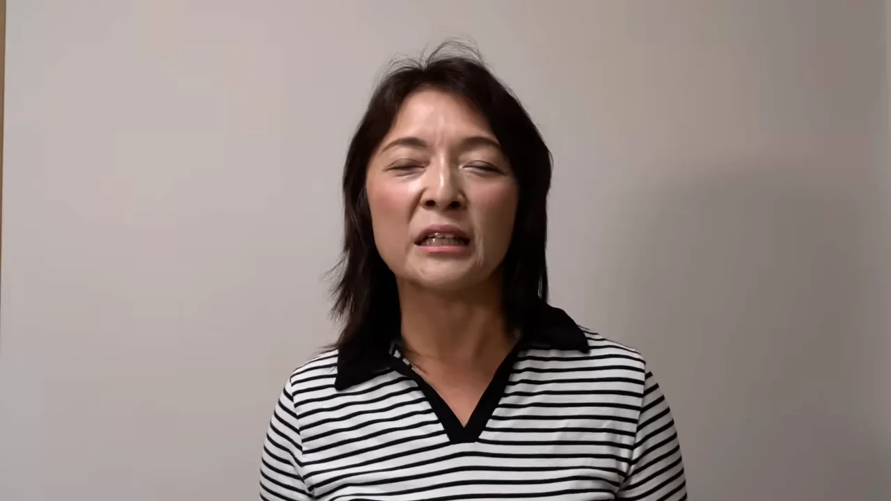 ボーダー柄の服を着た女性が目を細めながら話を続けています。