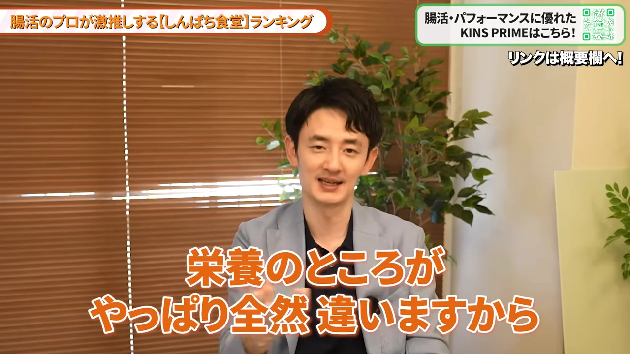 カメラに向かって話すグレーのジャケットを着た男性