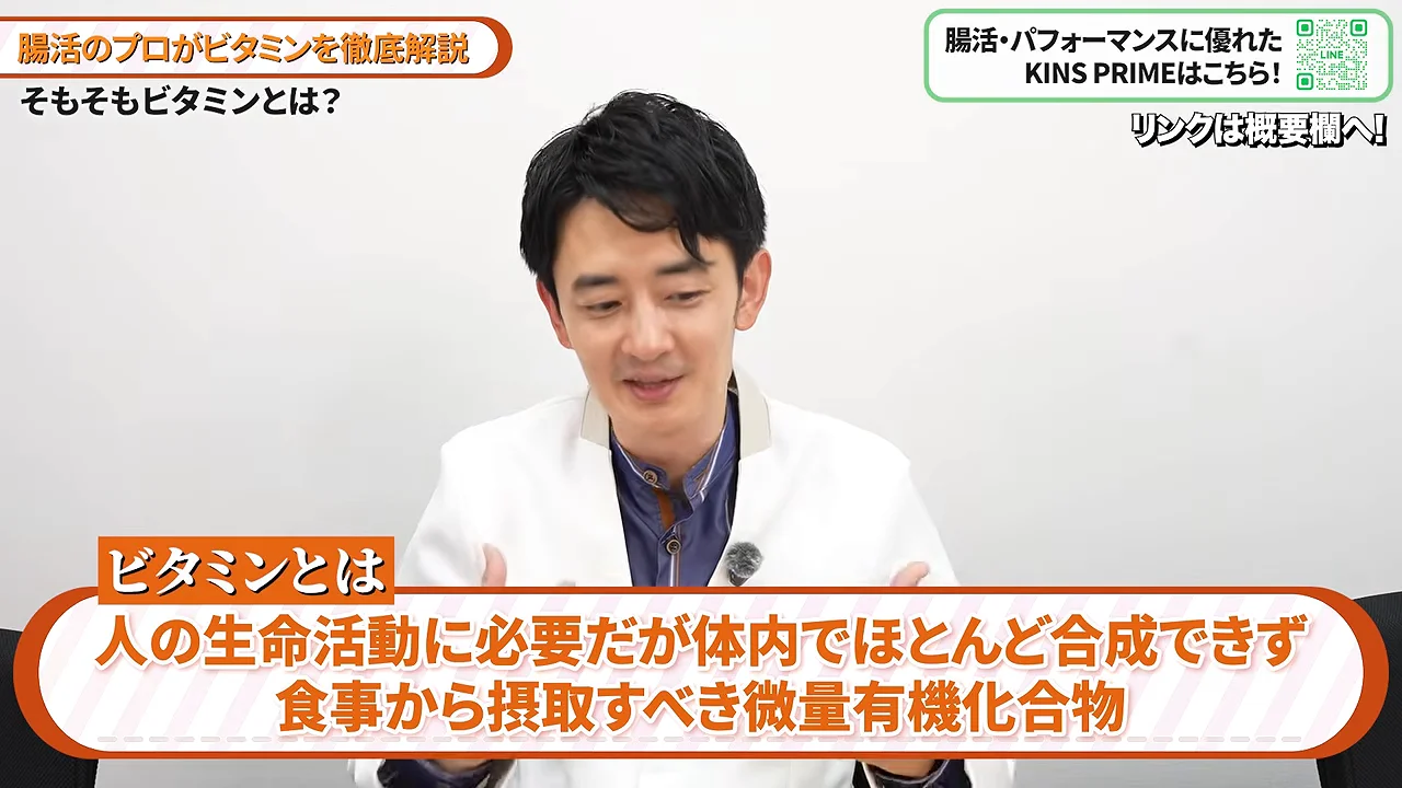 白い白衣を着た男性がビタミンの定義について説明している様子。