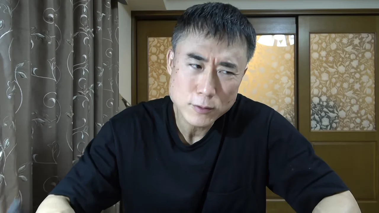 黒いシャツを着た男性がカメラに向かって話している様子。